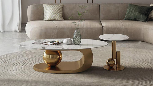 Calvero furniture set featuring a white marble-patterned ceramic coffee table and matching end table with sculptural golden bases.